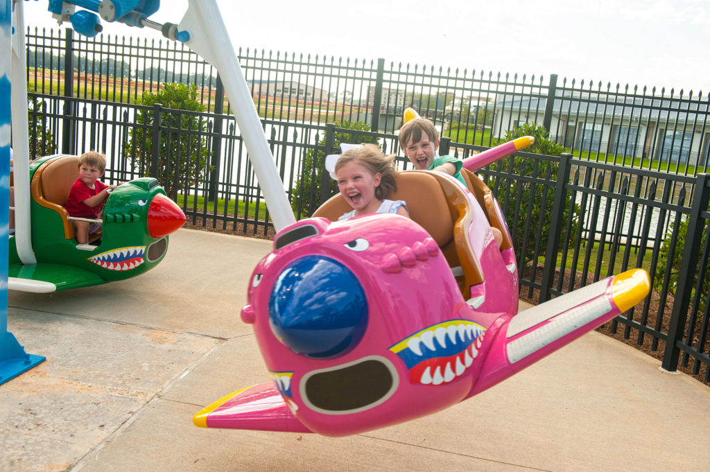 Two children riding in a pink plane