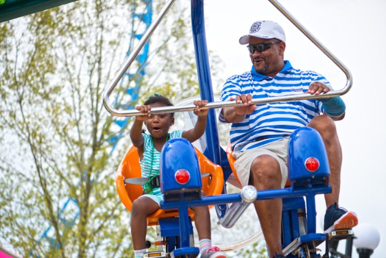 A family swinging through the air on the Flutter By ride