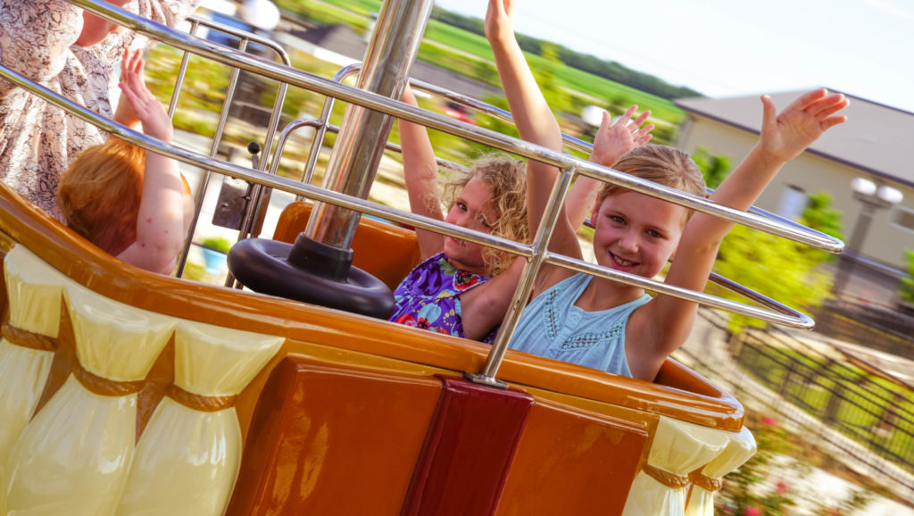 Children smiling while riding the Sky Balloons