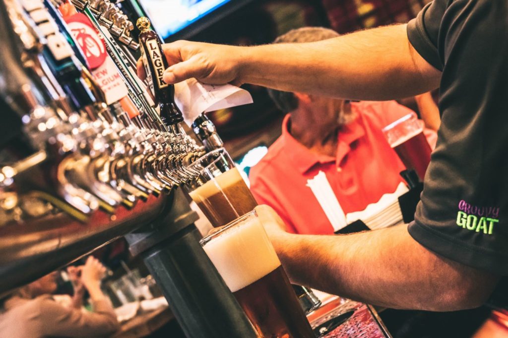 A server pouring a draft beer at Groovy Goat