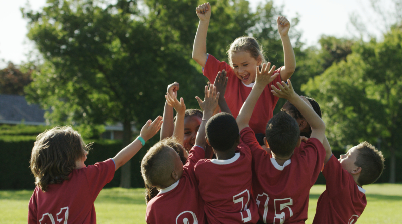 Kids soccer team cheering their teammate