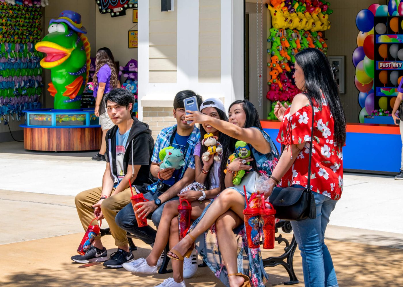 A group of young adults taking a selfie in front of The Park at OWA's Midway games